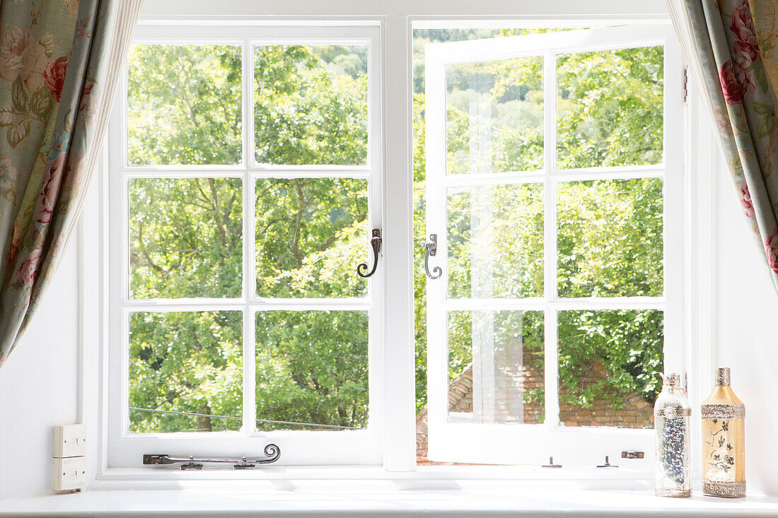 Vintage bottles on windowsill with view to garden from Petworth farmhouse West Sussex Kent