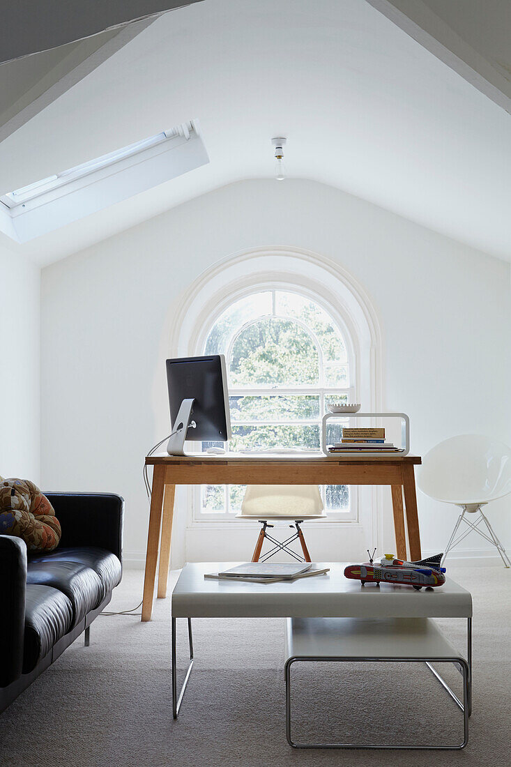 Computer screen on desk in spacious bright attic office  London  England  UK