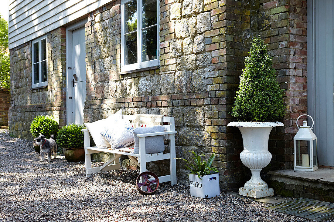 Bench with stone  brickwork and  weatherboard exterior of rural United Kingdom home