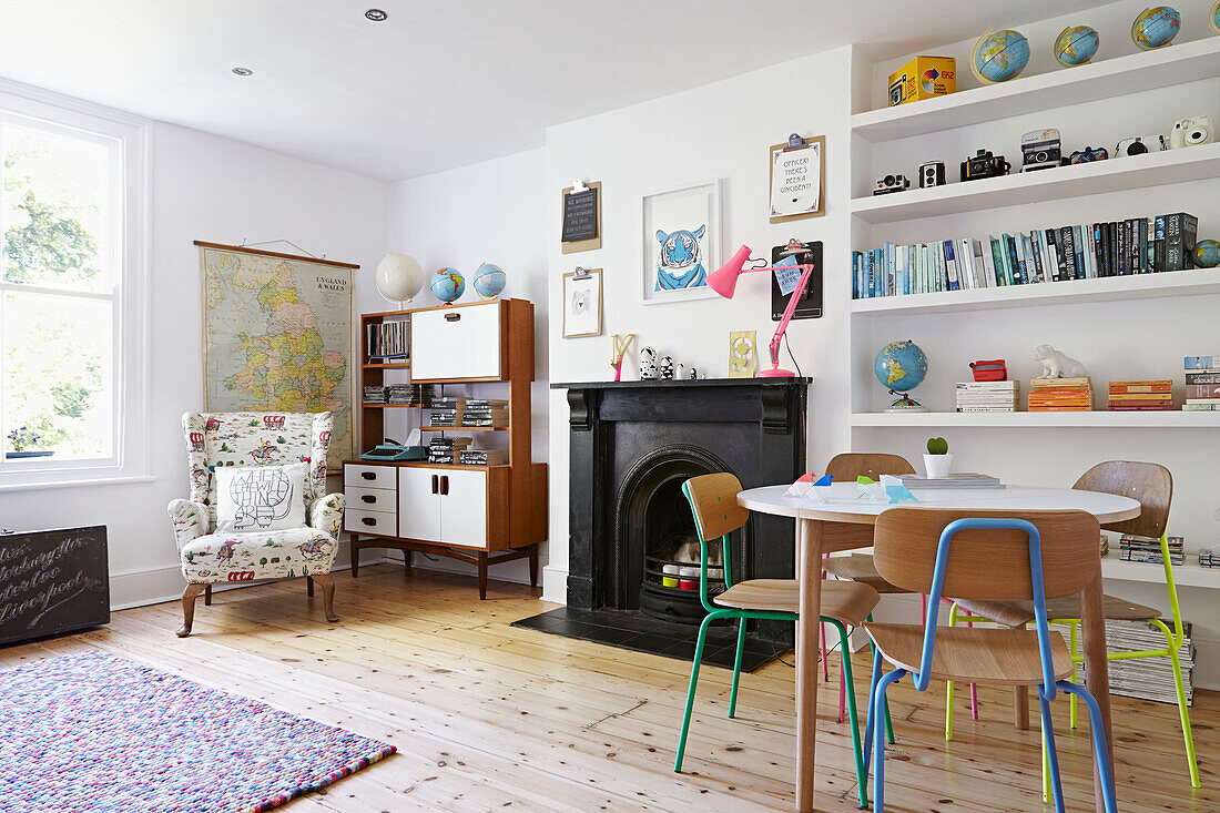 Sideboard im Retro-Stil mit schwarzem Kamin und Regalen im Wohnzimmer eines Londoner Einfamilienhauses, England, UK