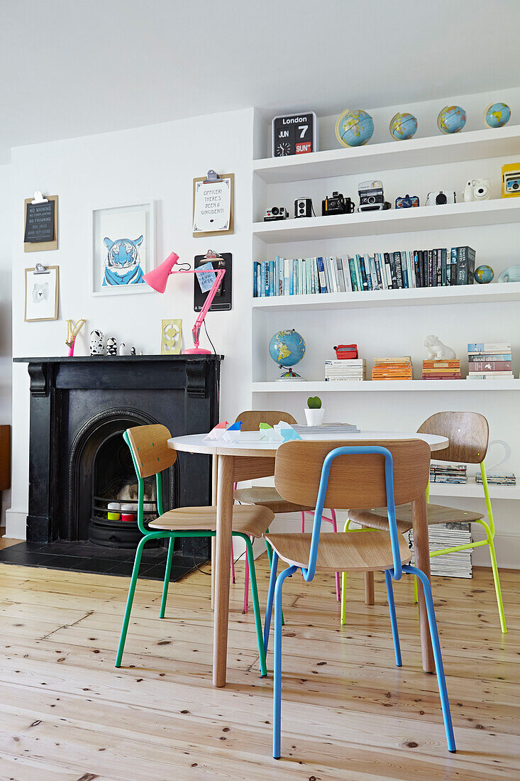 Black fireplace and shelving in living room of London family home  England  UK