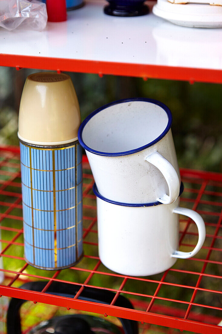 metal cups and flask on folding shelf in Brabourne garden,  Kent,  UK