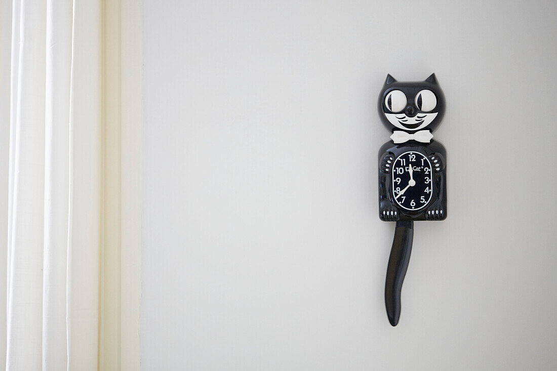 Black cat clock on white wall in Alloa home  Scotland  UK