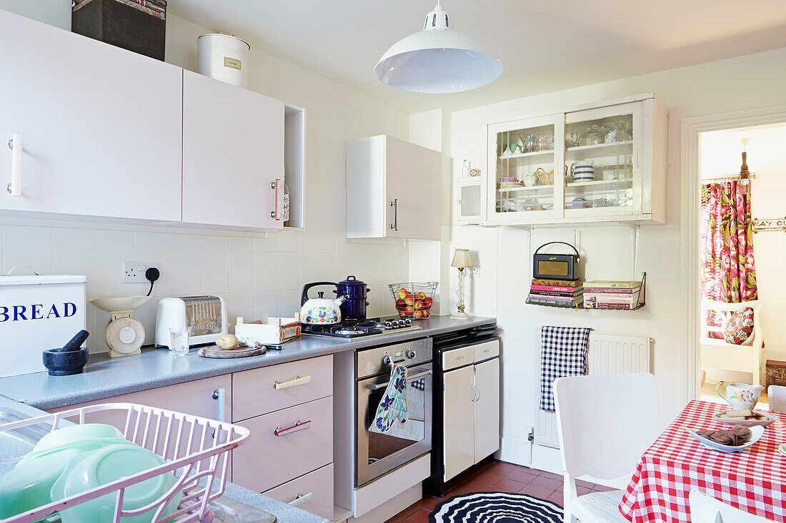 Kettle on hob with glass fronted kitchen cabinets in Faversham home,  Kent,  UK