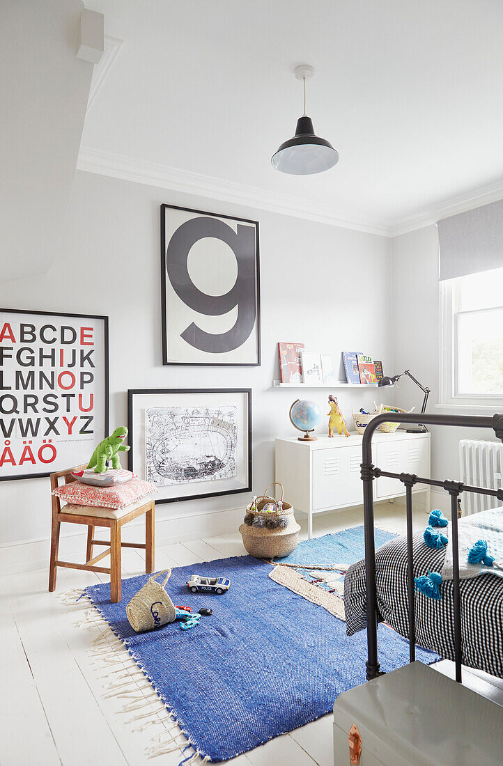 Framed artwork in boy's bedroom with blue rug  London home  UK