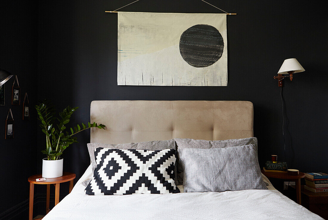 Black and white pillow under Oriental wall hanging in Sheffield bedroom  Yorkshire  UK