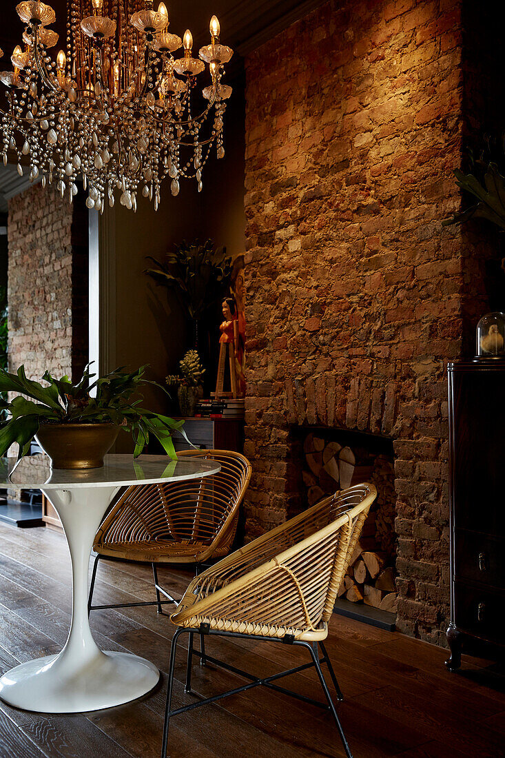 Cane chairs at Tulip table below glass chandelier in East London townhouse  England  UK