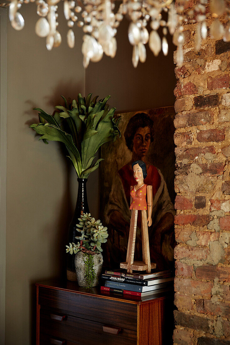 Leaf arrangements and books on polished cabinet with in East London townhouse  England  UK