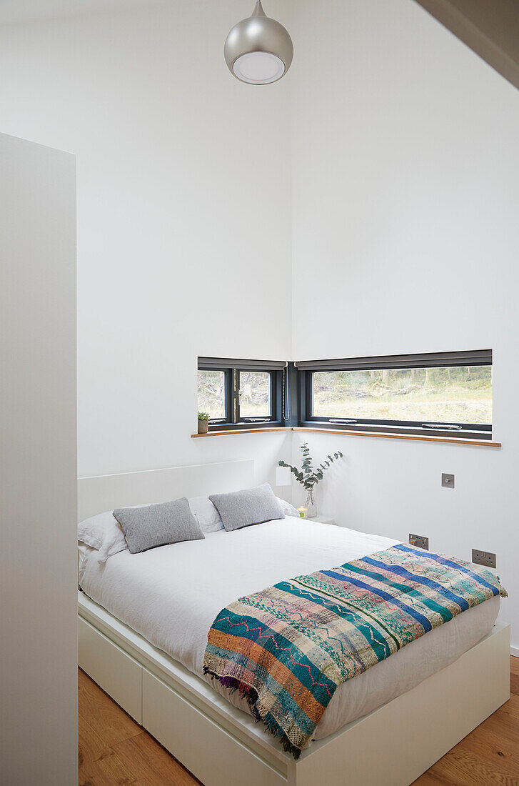 Patterned blanket on double bed in Devon new build  UK