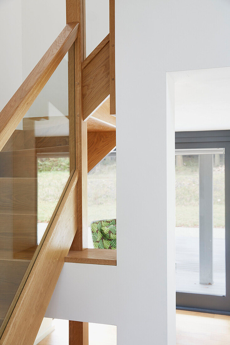 Glass and wooden banister in staircase of Devon new build  UK