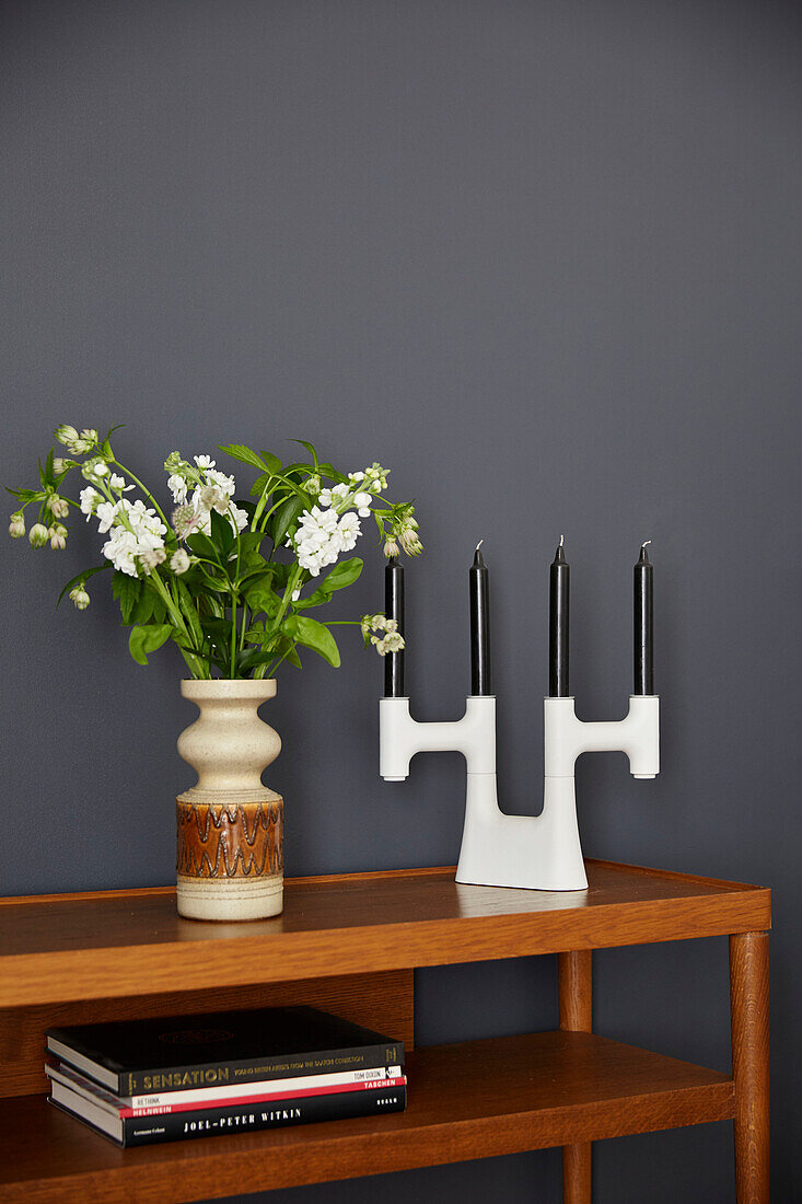 Vintage vase of flowers and candle holder on wooden table in modernised Preston home  Lancashire  England  UK