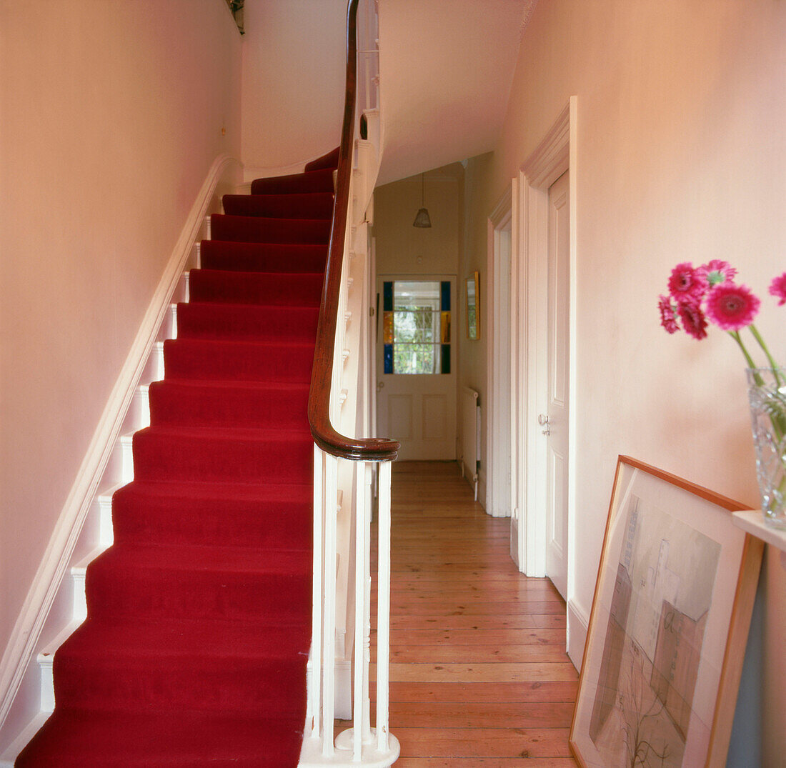 Hallway with bright red carpet runner in Victorian home
