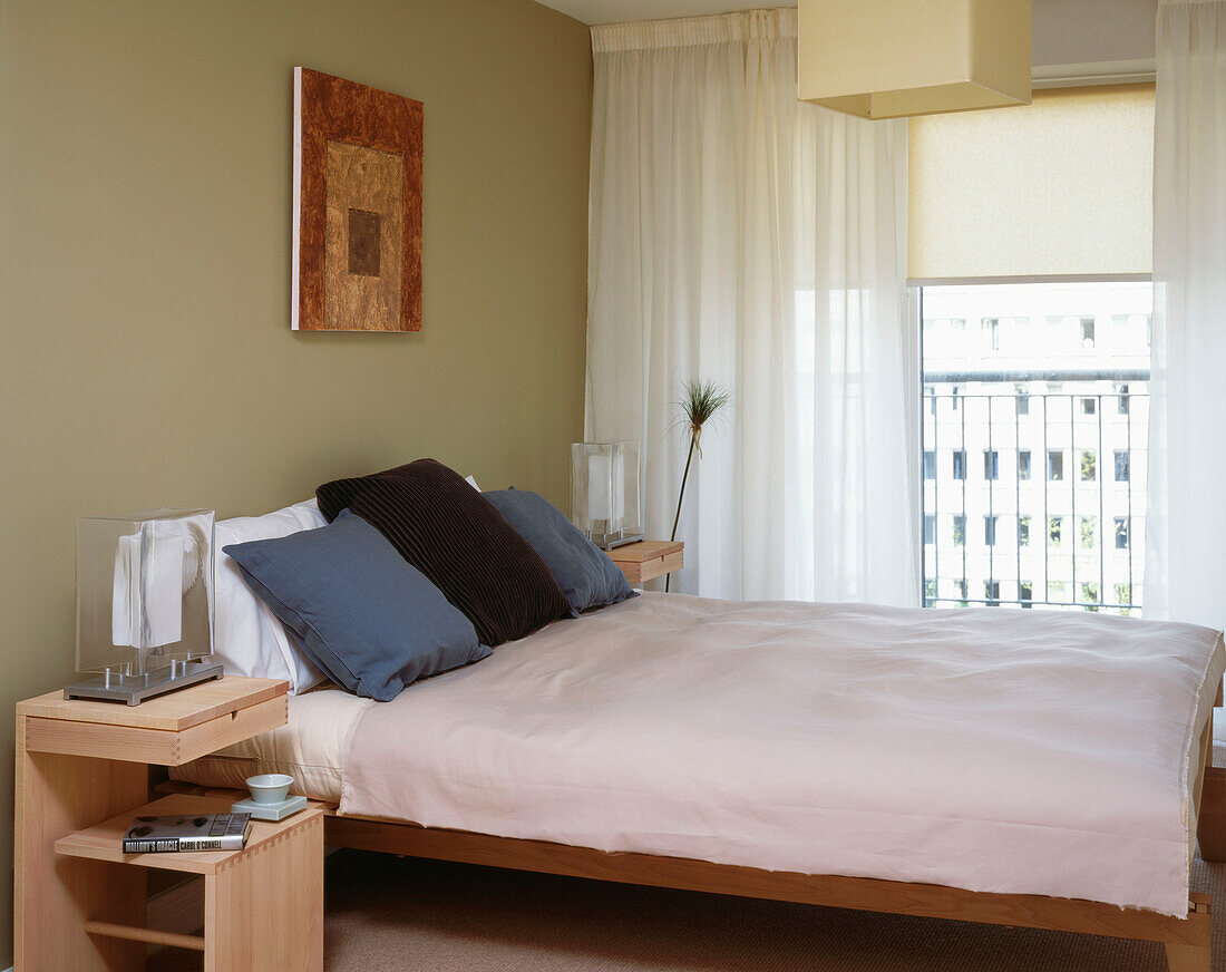 Bedroom with window and balcony and beige wall with abstract artwork