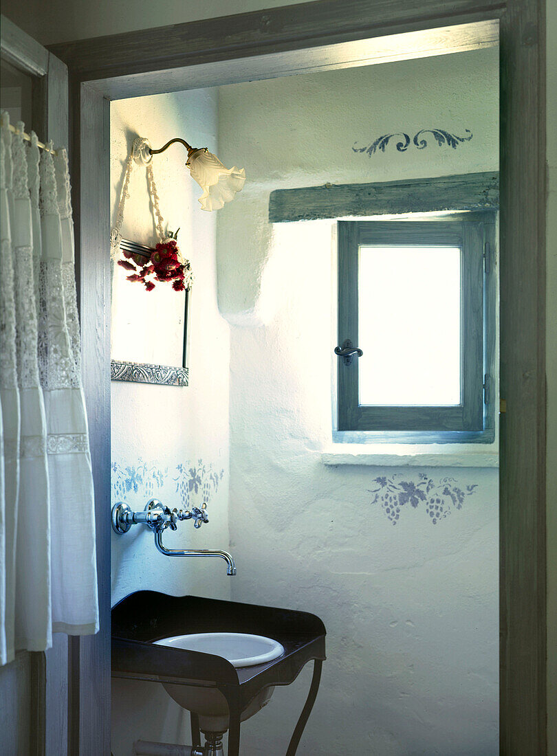 Traditional French bathroom with decorative stencils and pastel blue woodwork