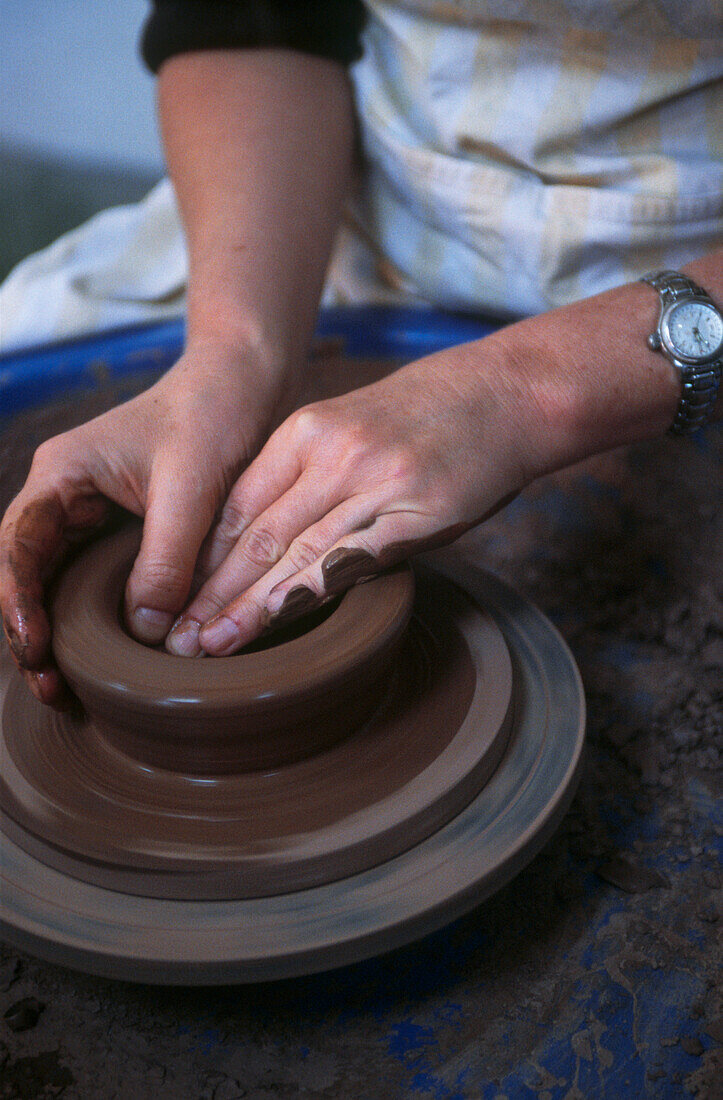 Potter throwing a pot on a potters wheel