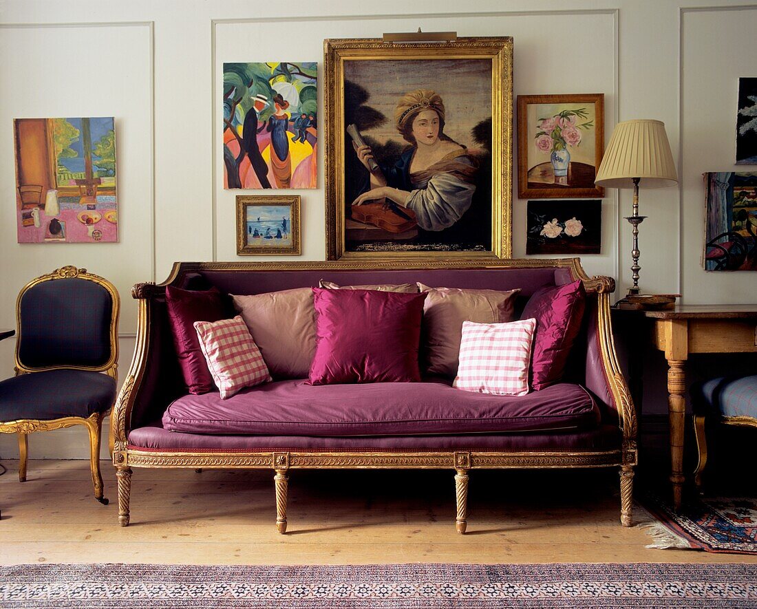 Purple upholstered vintage sofa with cushions in a wood paneled living room