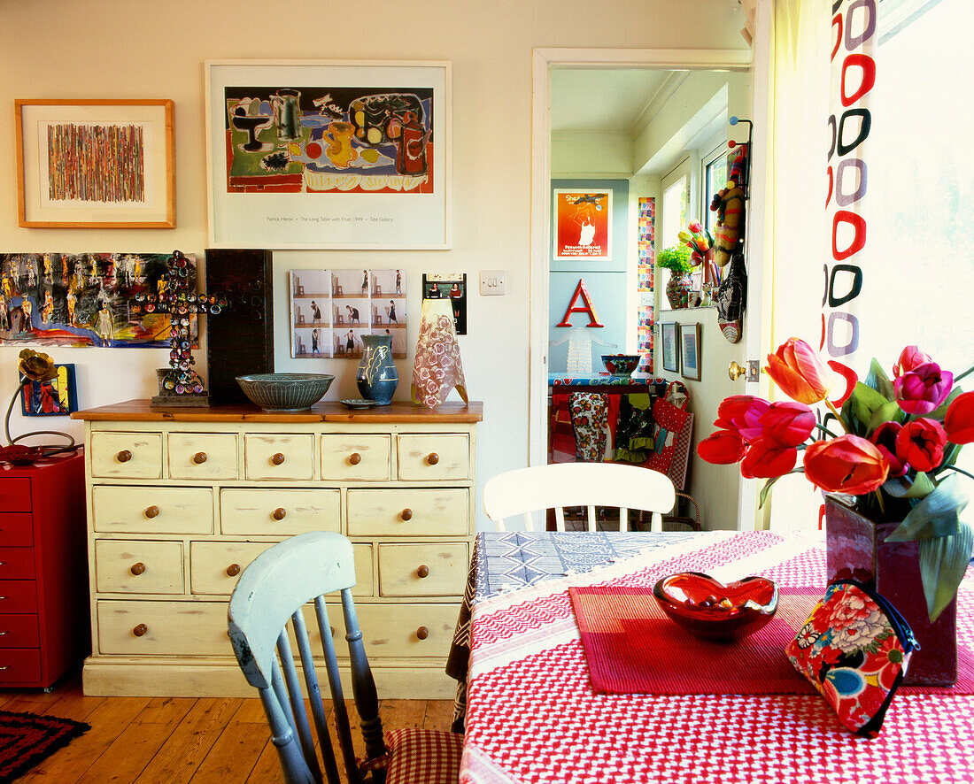 Brightly coloured 1950s style kitchen with painted chest of drawers for storage