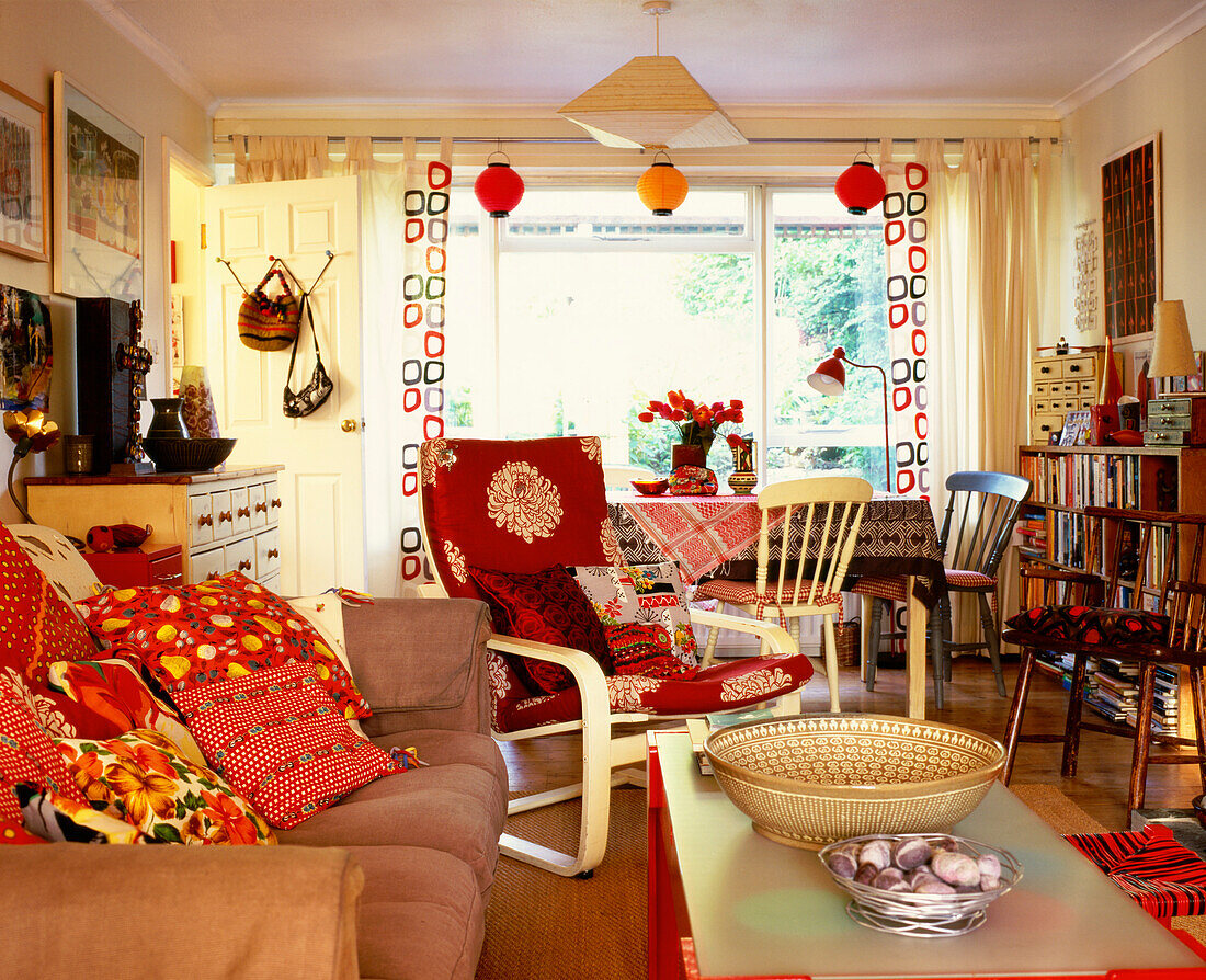 Off-white cotton curtains with a retro-style fabric and bright vintage cushions covered in fabric remnants 