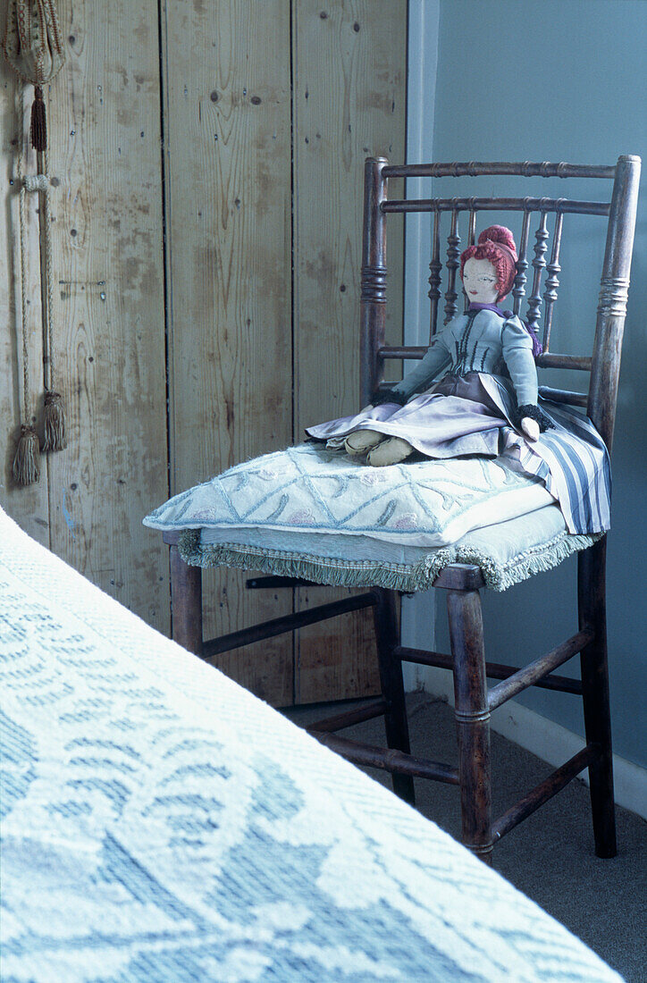 Rag doll on cushion of country cottage bedroom