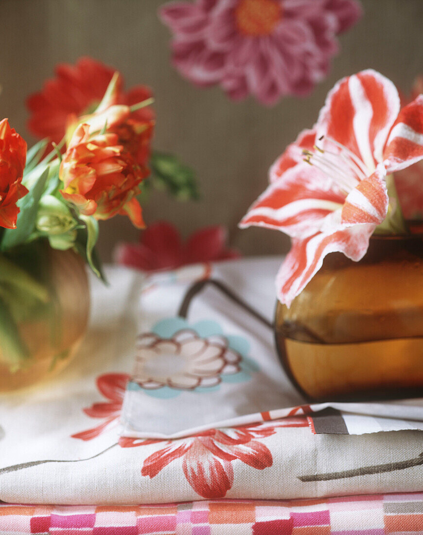 Vase with flowers on tablecloth with floral print