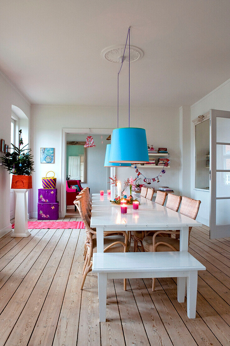 Blue pendant shades hang over painted Odense dining table