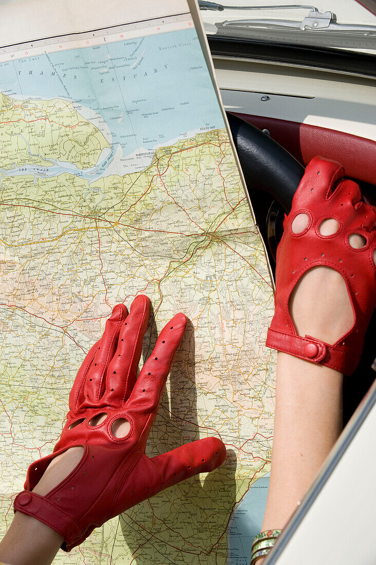 Karte mit roten Handschuhen im Autoinnenraum
