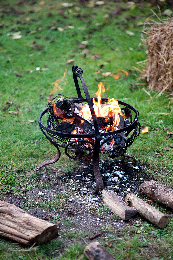 Brennende Holzscheite in einem schmiedeeisernen Gartenofen Yeovil Somerset, England, UK