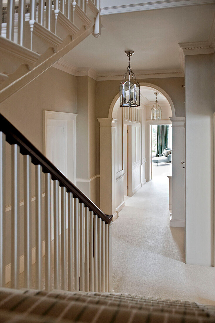 Staircase and corridor with arched architectural detail in West London townhouse England UK