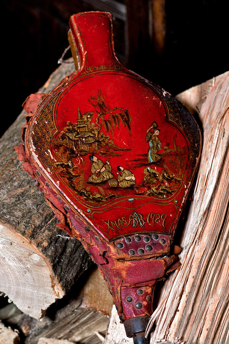 Red bellows with firewood in Cheltenham country home Gloucestershire England UK