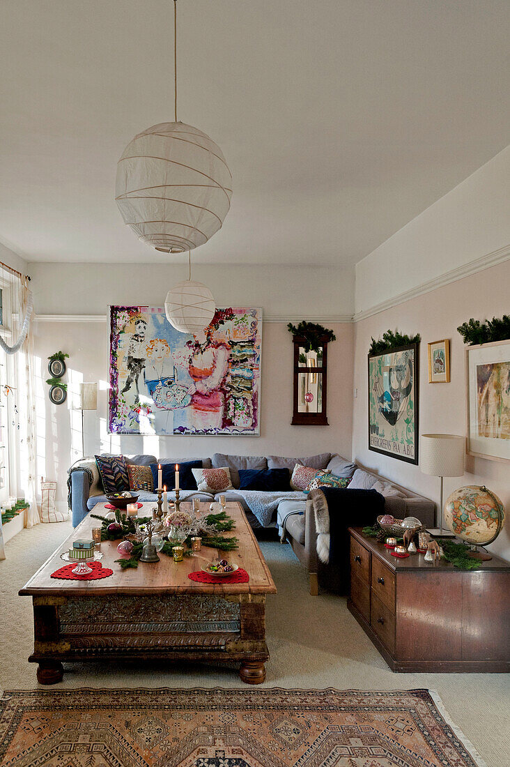 Blumengirlanden auf Kunstwerken im Wohnzimmer eines Hauses in Forest Row, Sussex, England, Vereinigtes Königreich