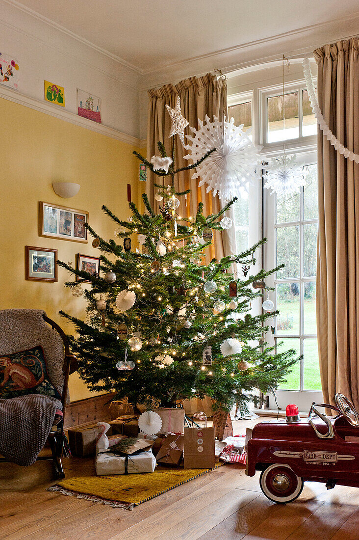 Presents and toy car under Christmas tree at window of Forest Row family home, Sussex, England, UK