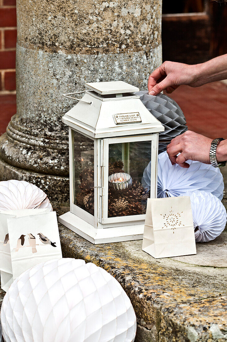 Preparing lanterns and Christmas decorations on outdoor steps of Forest Row country home, Sussex, England, UK