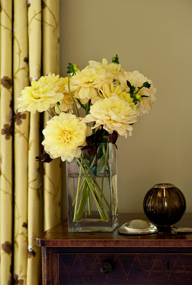 Cut flowers in vase on sideboard in rural Suffolk home England UK