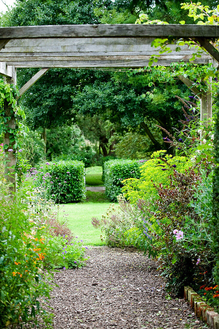 Woodchip path and pergola in grounds of rural Suffolk country house England UK