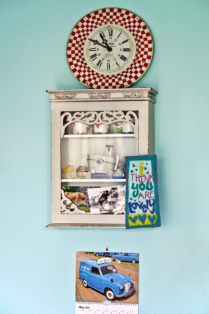 Wall mounted shelf with clock in kitchen of Bovey Tracey family home, Devon, England, UK