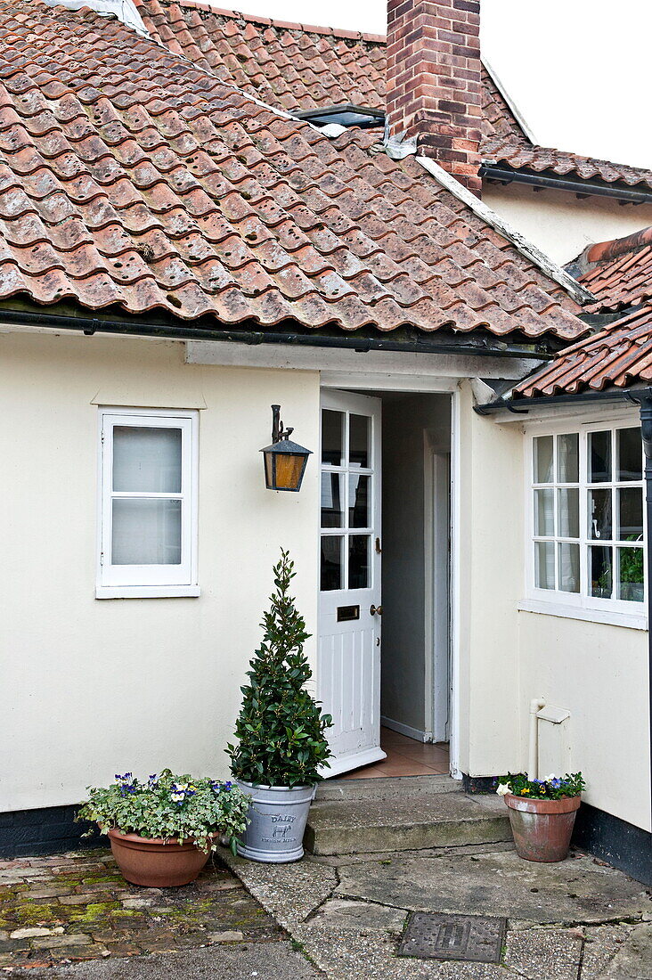 Open front door to tiled Suffolk cottage, England, UK
