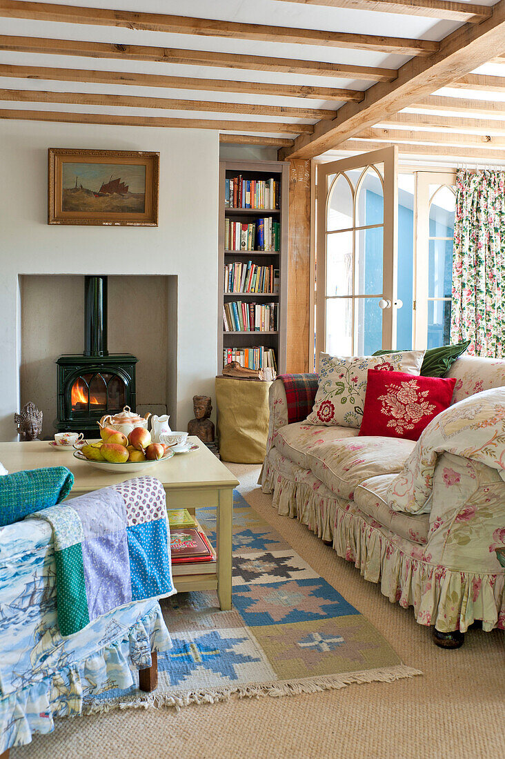 Beamed living room with wood burning stove in Essex home, England, UK