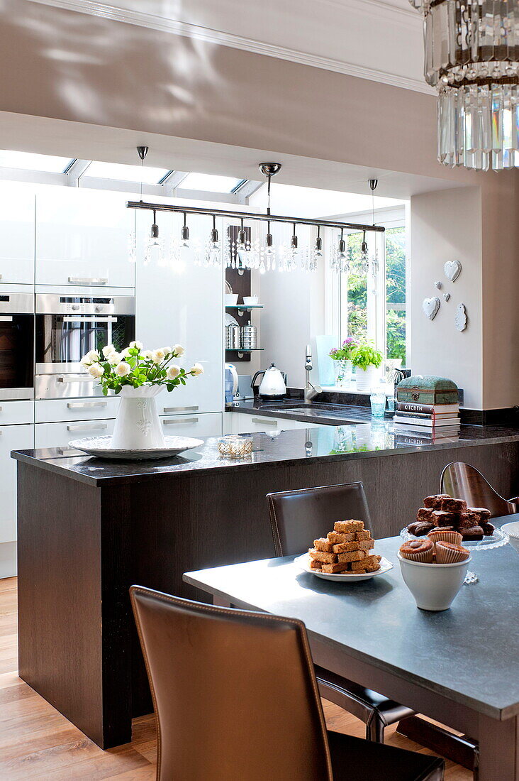 Cakes on table in open plan kitchen dining room of Middlesex family home, London, England, UK