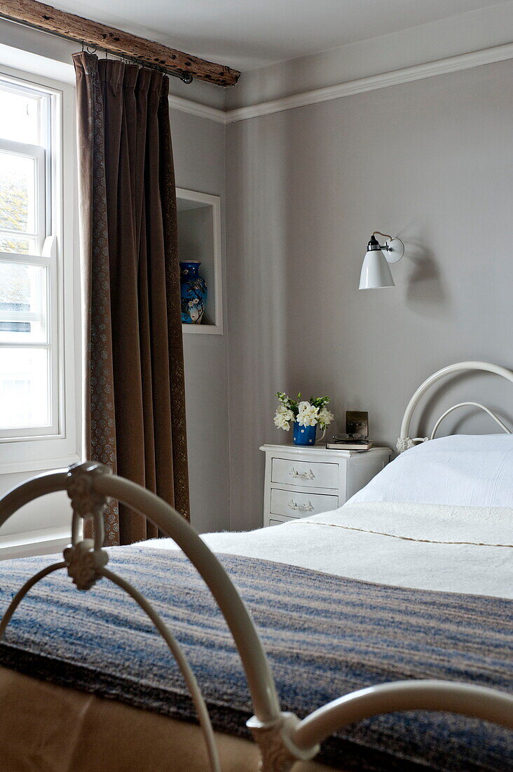 Woollen blanket on metal framed bed in Padstow cottage, Cornwall, England, UK