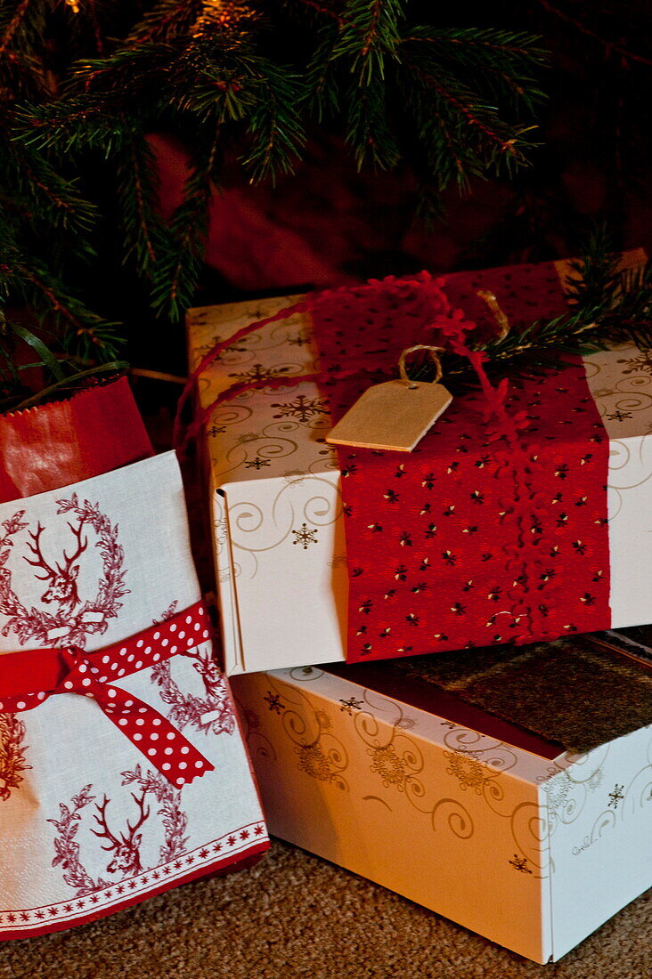 Three gift wrapped Christmas presents in Shropshire cottage, England, UK