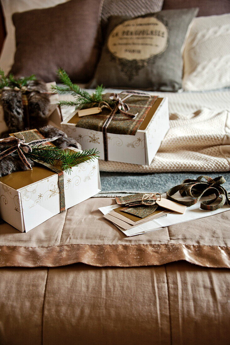 Gift wrapped presents on bed in Shropshire cottage, England, UK