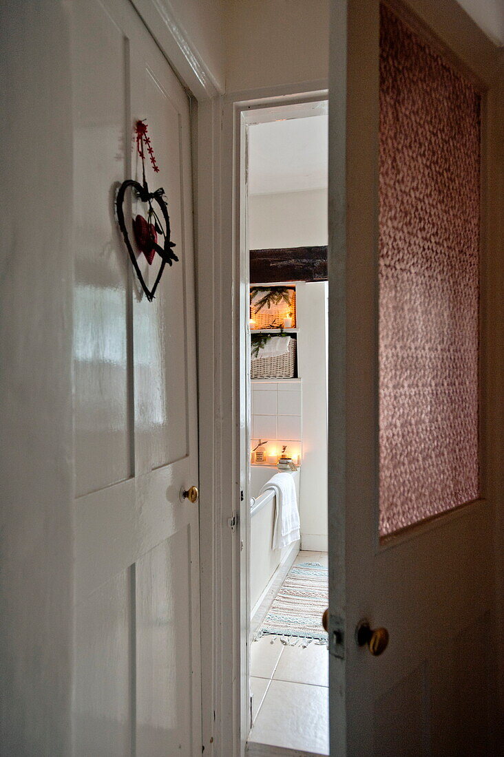 Heart shaped ornament and view through doorway to bathroom of Shropshire cottage, England, UK