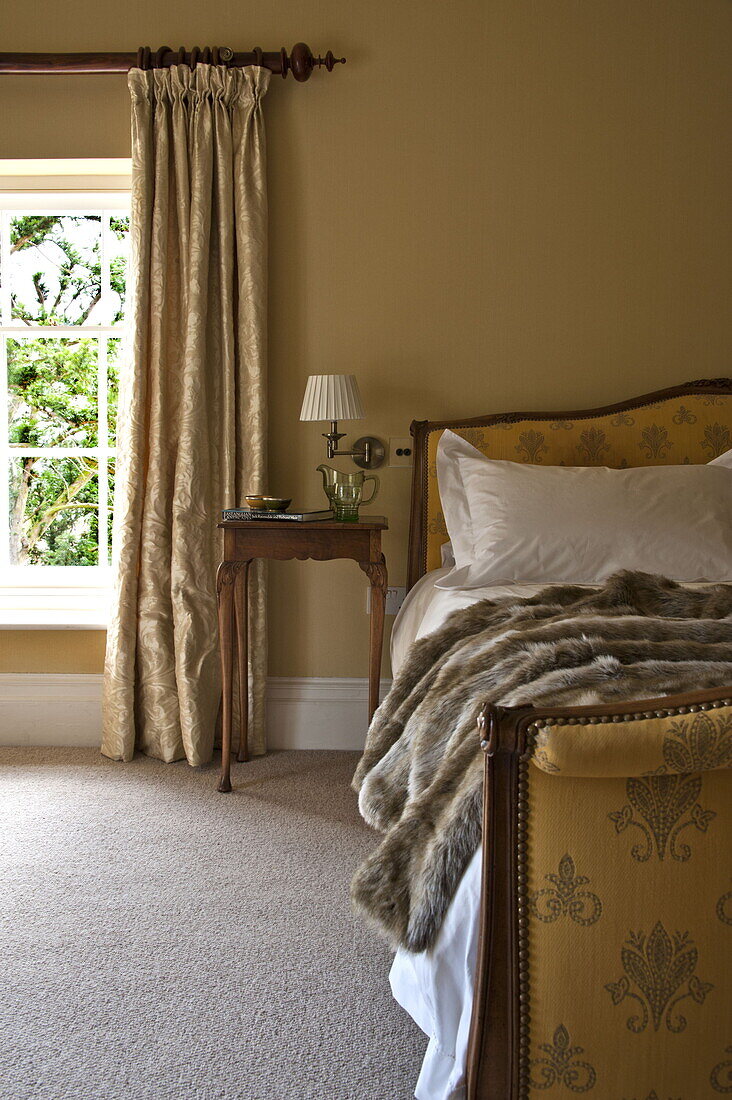 Doppelbett mit Fellüberwurf in einem modernen Landhaus in Suffolk, England, UK