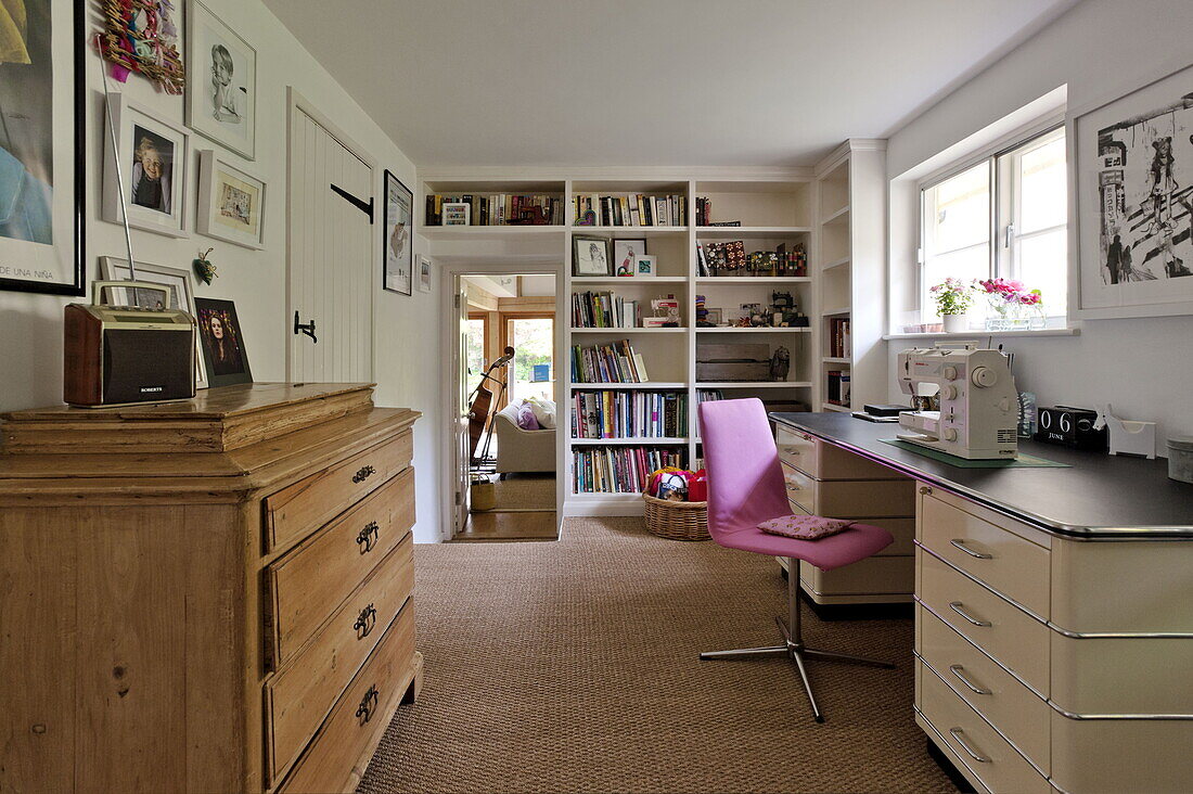 Pink chair at workbench with sewing machine in contemporary Suffolk/Essex home, England, UK