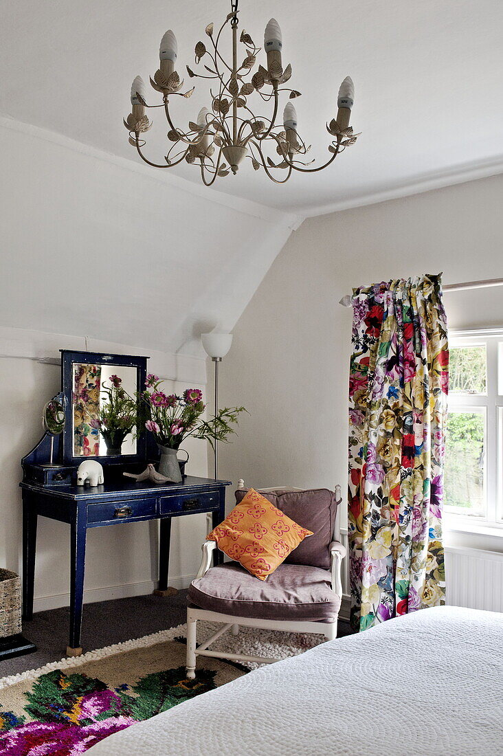 Bunte Blumenvorhänge mit blauem Schminktisch im Schlafzimmer eines modernen Hauses in Suffolk/Essex, England, Vereinigtes Königreich