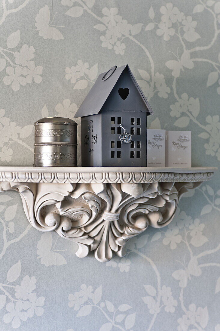 Grey model home with metal storage tins on plasterwork shelf in Bury St Edmunds country home, Suffolk, England, UK