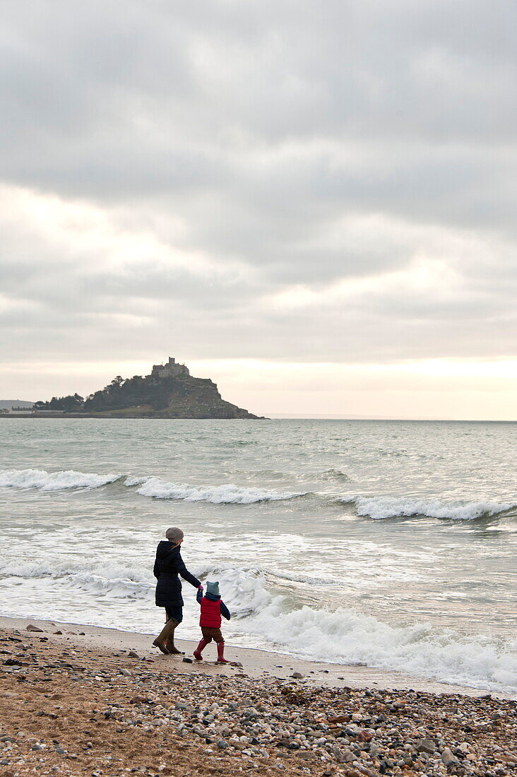 Mother and son walking on beach Penzance Cornwall England UK