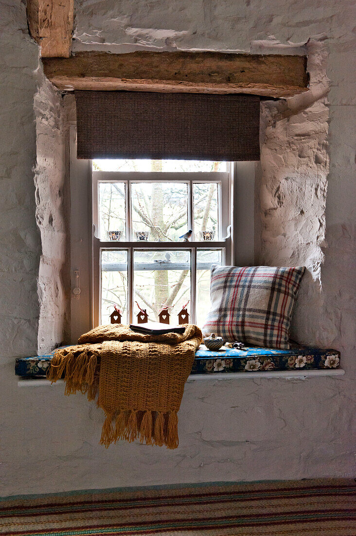 Tartan-Kissen und -Decke auf der Fensterbank in einem Haus in Tregaron, Wales, Vereinigtes Königreich