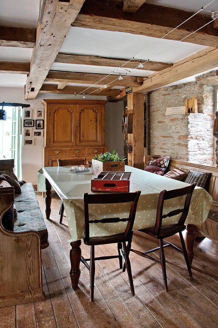 Esstisch und Stühle mit gepunkteter Tischdecke in einer umgebauten Scheune in Sherford, Devon, Großbritannien