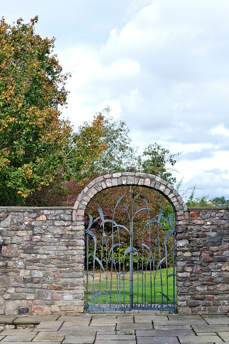 Gewölbtes Metall-Gartentor im Garten eines Bauernhauses, Blagdon, Somerset, England, UK